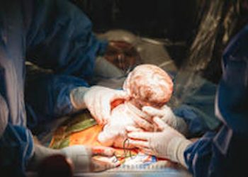 Emily Dial is shown delivering her own daughter (Image courtesy of Sarah Hill Photography)