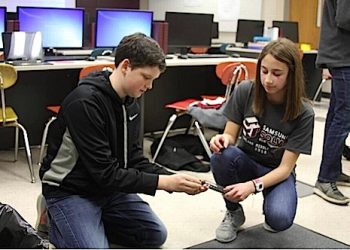 Students at Ashland Middle School demonstrate how to pick up used needles with the device they invented. (Photo by Will Wright Lexington Herald Leader)